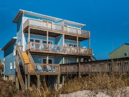 a blue house with a deck on the beach at Sand By Me in Surf City