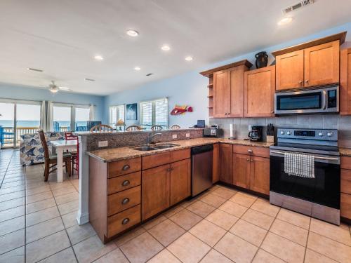 a large kitchen with wooden cabinets and a dining room at Sand By Me in Surf City