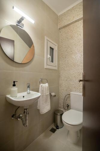 a bathroom with a sink and a toilet and a mirror at Ethereal Oasis Penthouse in Salamís