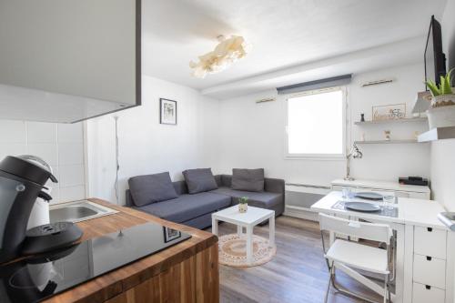une cuisine et un salon avec un canapé et une table dans l'établissement Studio aux portes des remparts !, à Avignon