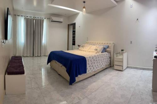 una camera da letto con un letto grande con una coperta blu di Casa - período do festival a Parintins
