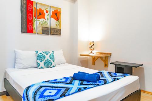 een slaapkamer met een bed met een blauwe deken erop bij HOM Roma in Mexico-Stad