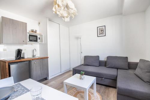 un salon avec un canapé et une cuisine dans l'établissement Studio aux portes des remparts !, à Avignon