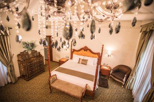 a bedroom with a bed and a chandelier at Aranwa Cusco Boutique Hotel in Cusco