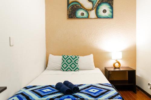 a small bedroom with a bed with two eyes on the wall at HOM Centro histórico in Mexico City