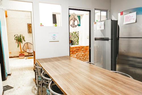 a kitchen with a wooden table and a refrigerator at HOM Centro histórico in Mexico City