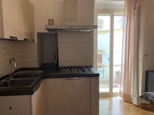 a kitchen with a stove and a sink and a window at Casa Maria in Grottaglie