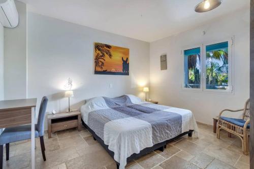a bedroom with a bed and a desk and two chairs at Ocean Breeze Apartments #33 in Kralendijk