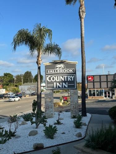 a sign for a valley roof country inn with palm trees at Fallbrook Country Inn in Fallbrook