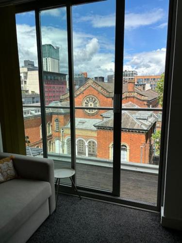a living room with a view of a building from a window at Luna Stays Ltd apartment 37 in Birmingham
