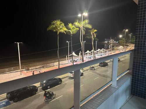 a bridge over a street with palm trees at night at Blue Sunset Beira Mar in João Pessoa