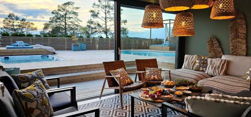 a living room with a couch and chairs and a pool at Privat Spirit Spa Villa in Vallentuna