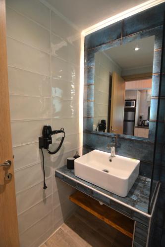 a bathroom with a sink and a mirror at The Thassian Yard Houses in Prinos