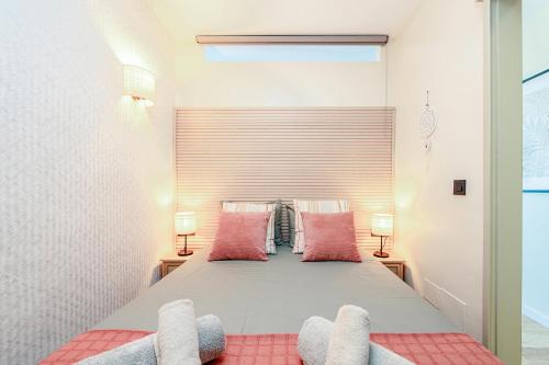 a bedroom with a large bed with pink pillows at BeachSide Maspalomas FKK friendly in Maspalomas