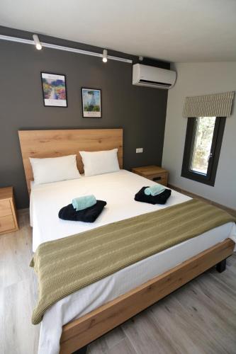 a bedroom with a large bed with two towels on it at The Thassian Yard Houses in Prinos