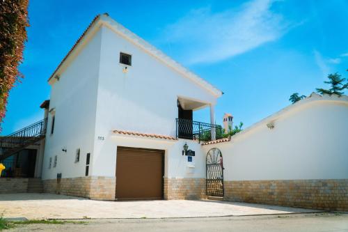 a white church building with a garage at Villa Belvue - Big Pool & Private Parking - 500m Sea in Medulin