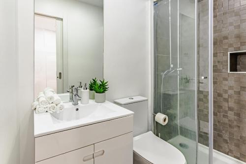 un bagno bianco con lavandino e doccia di Visit Lisbon4fun - Alfama a Lisbona