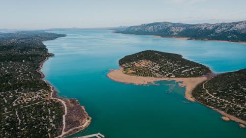 an island in the middle of a body of water at Lavender residence Villa Drage with pool and wellness in Drage
