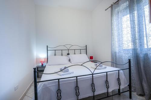 a bedroom with a bed with a wrought iron frame at Home Le Castella in Le Castella