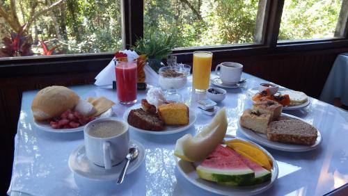 a table with a bunch of breakfast foods on it at Hotel Refazenda in Visconde De Maua