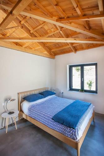 a bedroom with a large bed with a wooden ceiling at Villa Vouno - luxury and privacy in the Aegean in Klíma