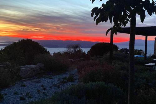 a sunset on a hill with a view of the ocean at Villa Vouno - luxury and privacy in the Aegean in Klíma