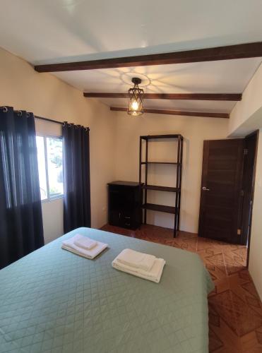 a bedroom with a bed with two towels on it at Rooftop "Montalvo" in Baños