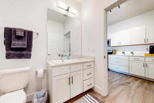 a white bathroom with a sink and a mirror at 2 Mi to UF Campus! Dog-Friendly Condo w/ Pool in West Hills