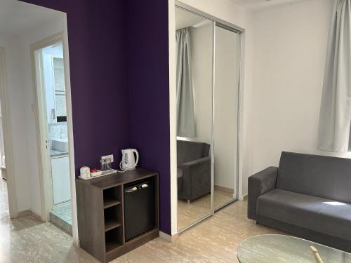 a living room with a couch and a mirror at St Elena Boutique Residence in Larnaka