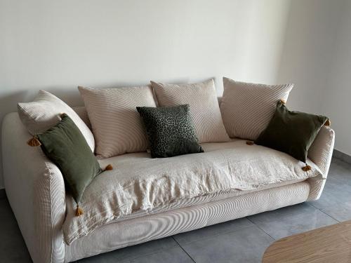 - un canapé blanc avec des oreillers dans l'établissement Charmant T2 vue mer, à Ajaccio