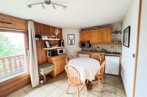 une cuisine avec une table et des chaises et une fenêtre dans l'établissement Charming T2 in Saint-Gervais-les-Bains, à Saint-Gervais-les-Bains
