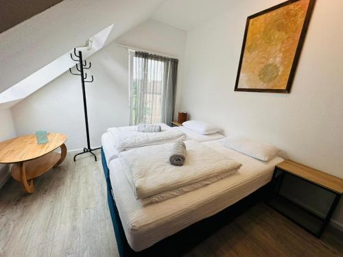 シュトゥットガルトにあるCity Suitesのランプとテーブル付きの部屋のベッド2台