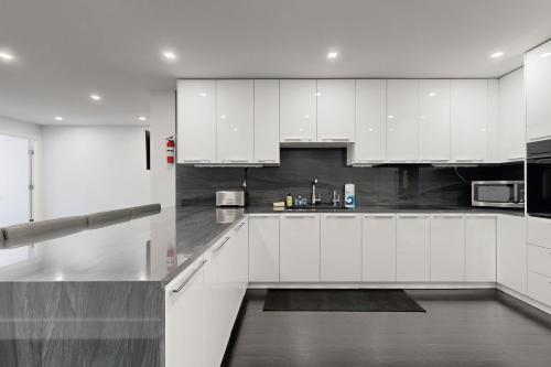 a kitchen with white cabinets and a refrigerator at The 1-Main St in Bar Harbor