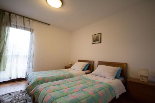 1 dormitorio con 2 camas y ventana en Apartment Cherry, en Rovinj