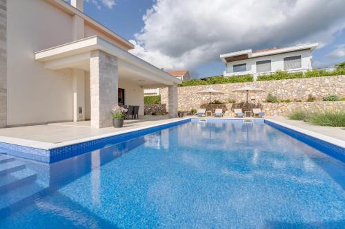 a swimming pool in front of a house at Villa Mihojka in Malinska