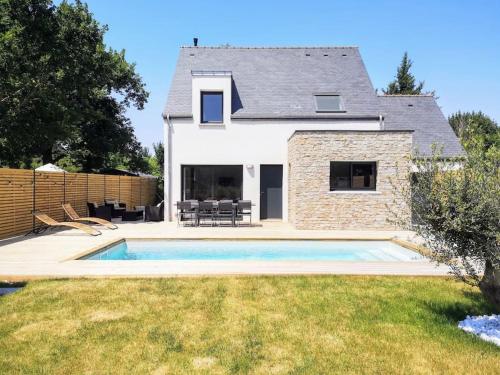 une maison avec une piscine devant une maison dans l'établissement Piscine - Maison Moderne - Route des Plages, à Saint-Philibert
