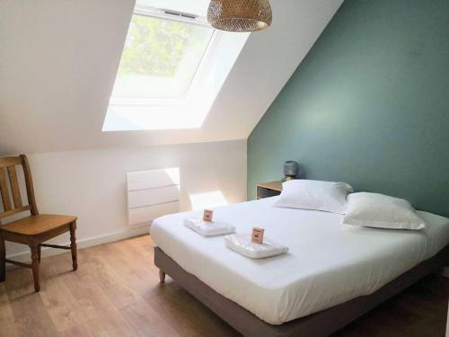 - une chambre avec un lit doté d'une lucarne et d'une chaise dans l'établissement Piscine - Maison Moderne - Route des Plages, à Saint-Philibert
