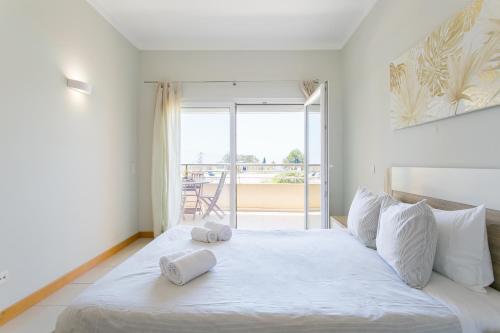 een slaapkamer met een groot wit bed met handdoeken erop bij Quinta da Barracuda by Golden Zenith in Albufeira