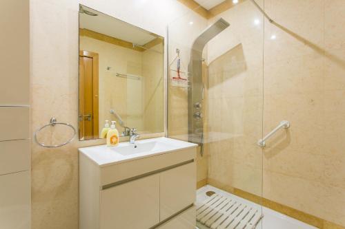 een badkamer met een wastafel en een glazen douche bij Quinta da Barracuda by Golden Zenith in Albufeira