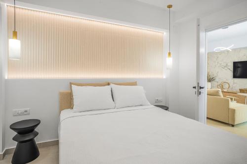 a bedroom with a white bed and a chair at Infinity luxury suite in Malia