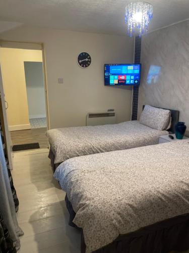 a room with three beds and a television on the wall at One Bedroom Apartment Filton in Bristol
