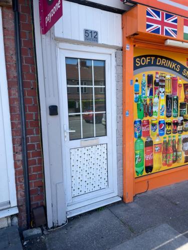 a door to a store with a display of soft drinks at One Bedroom Apartment Filton in Bristol