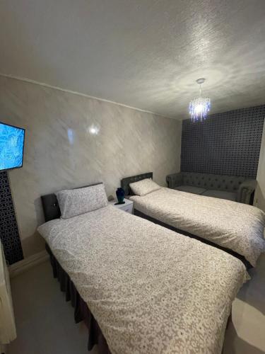 a bedroom with two beds and a tv on the wall at One Bedroom Apartment Filton in Bristol