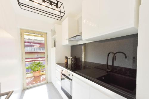 une cuisine blanche avec un évier et une fenêtre dans l'établissement Apartment with Terrace walk to Beaches & Shopping, à Cannes