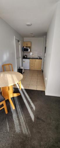 a kitchen with a table and chairs in a room at ASURE Central Gold Motel Cromwell in Cromwell
