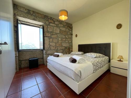 una camera da letto con un letto e un muro di mattoni di Casa Curto a Terras de Bouro