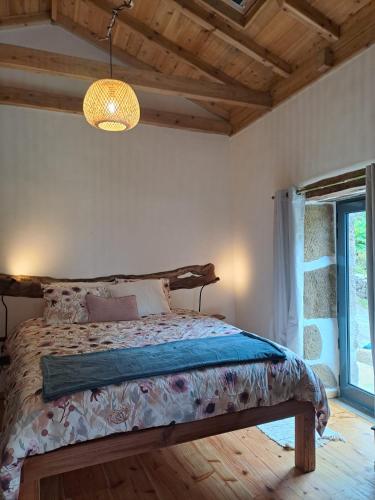 a bedroom with a bed and a large window at Casa Azorina - Casas Florescer in Fajazinha