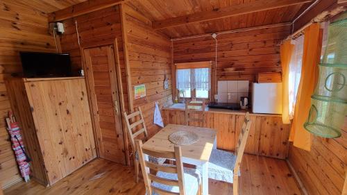 a dining room with a table and chairs in a cabin at Siedlisko Białogóra in Białogóra