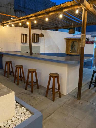 a bar with stools in front of a counter at Hotel Casa Juanita in Puerto Escondido