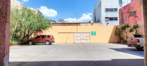 a car parked in a parking lot in front of a building at Hoteles Santa Regina in Chihuahua